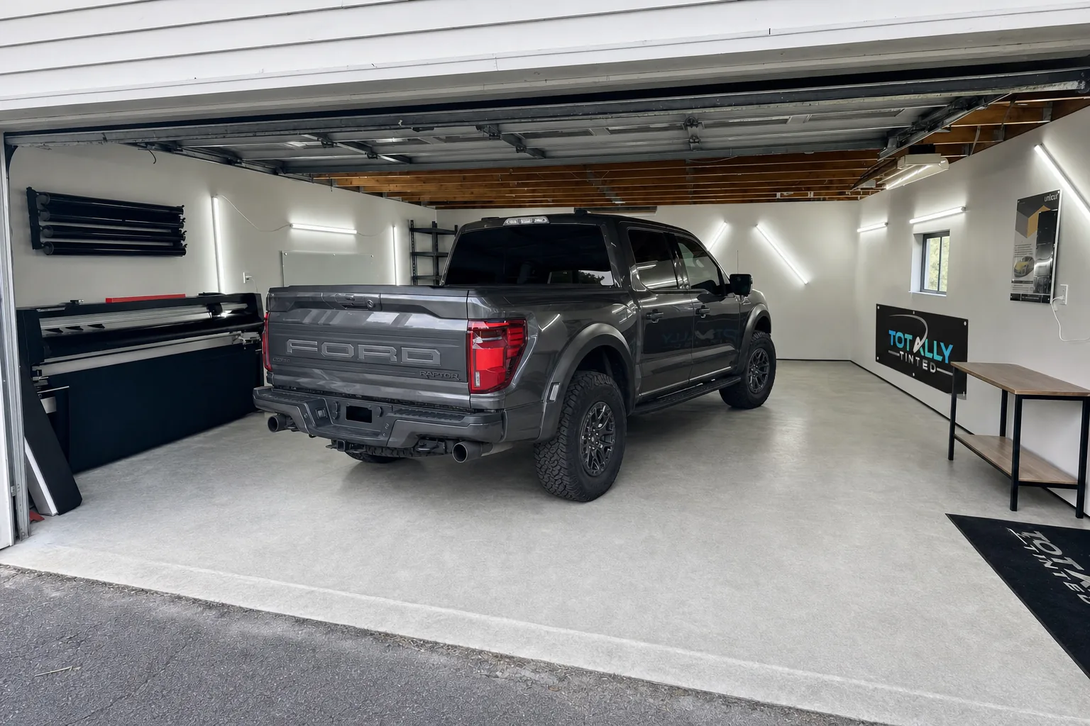 Graphite grey Ford F-150 Raptor with freshly tinted windows in the Totally Tinted garage studio