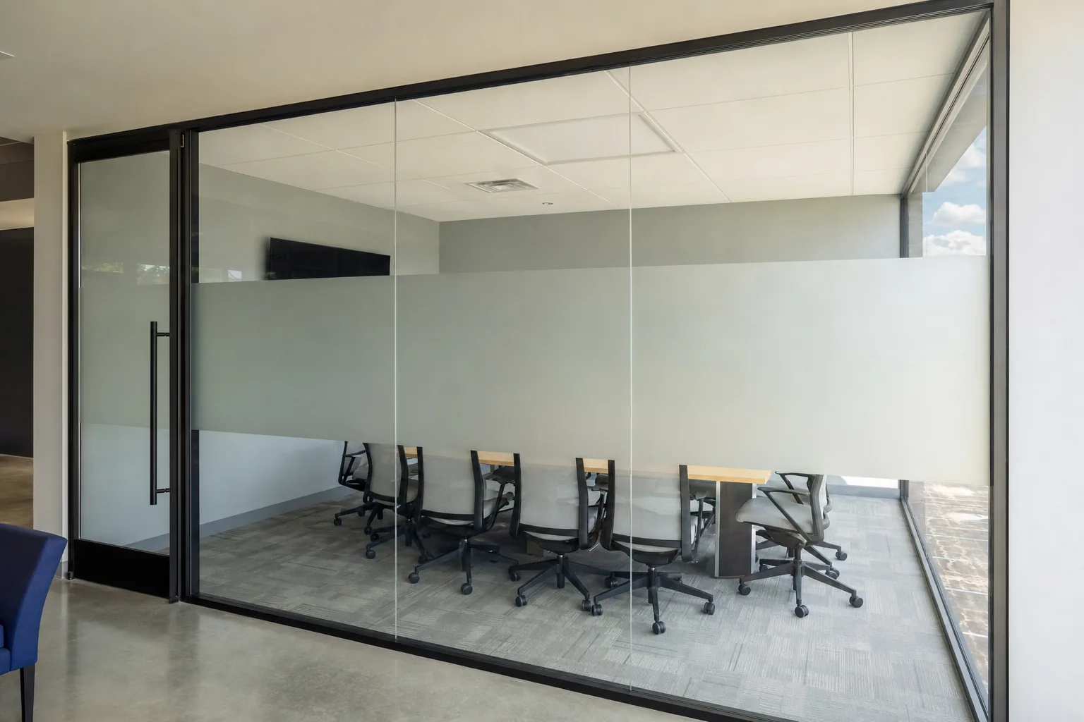A glass conference room with a frosted privacy band