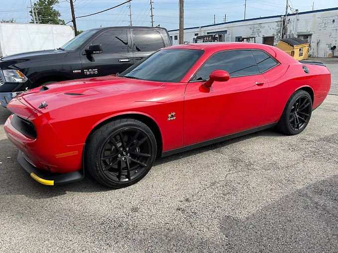 A red Dodge Challenger with tinted windows, a Totally Tinted job
