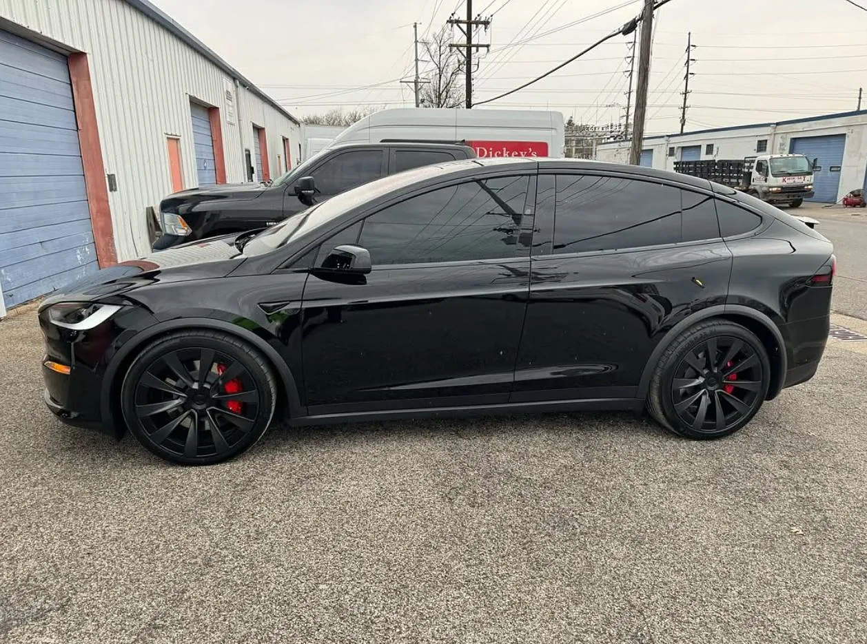 A black Tesla Model X with tinted windows, a Totally Tinted job