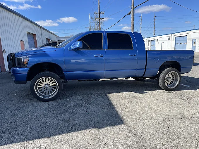 A blue Ram pickup with tinted windows, a Totally Tinted job