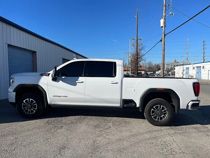 A white GMC Sierra with tinted windows, a Totally Tinted job
