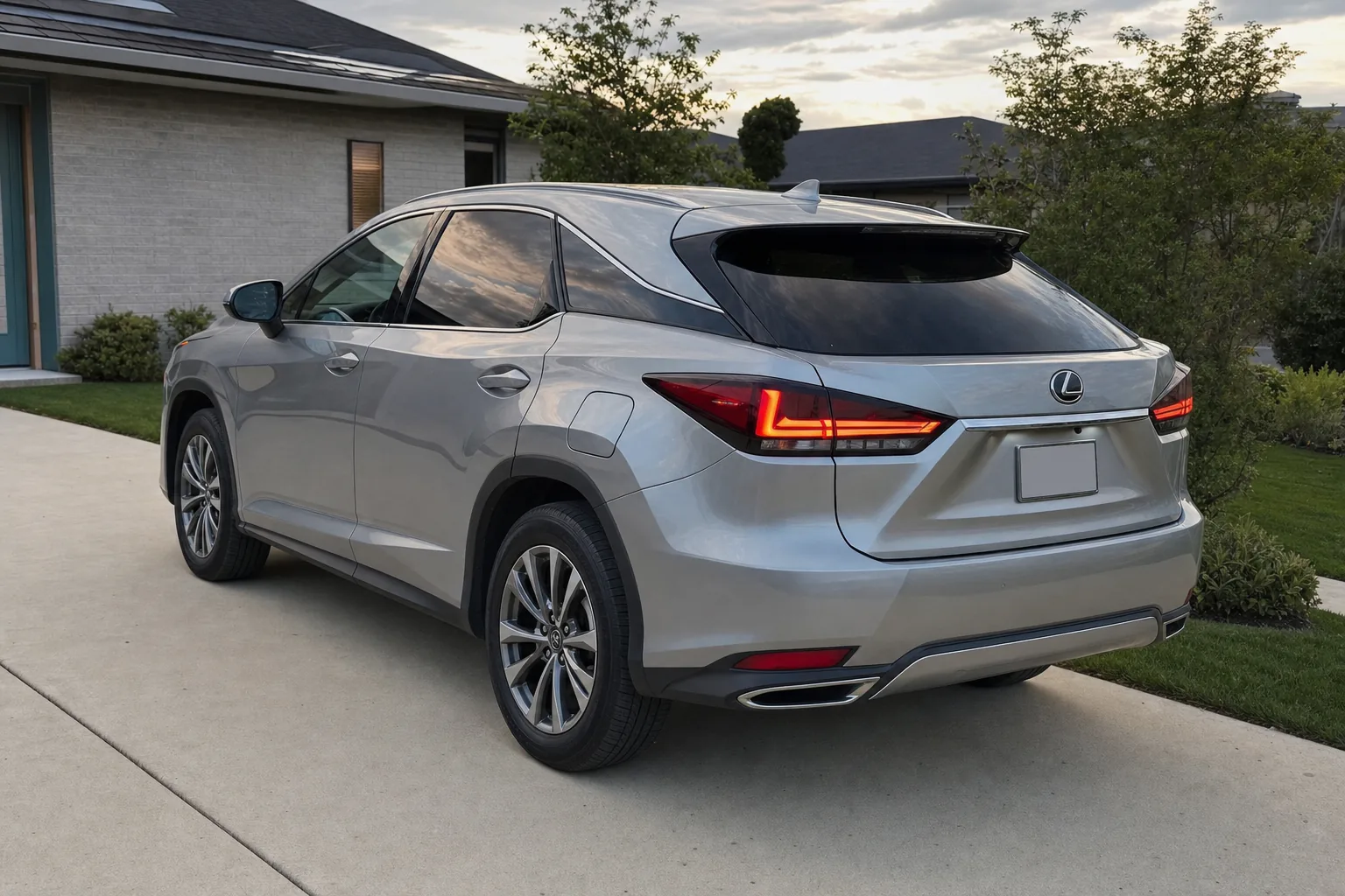 A silver Lexus RX with smoked taillights on a home driveway