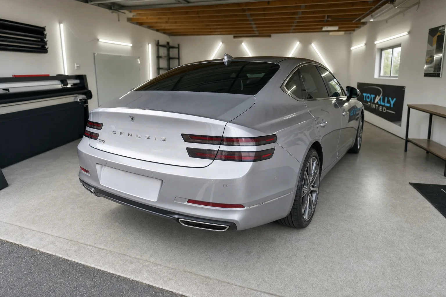 Liquid silver Genesis G80 with freshly tinted windows in the Totally Tinted garage studio
