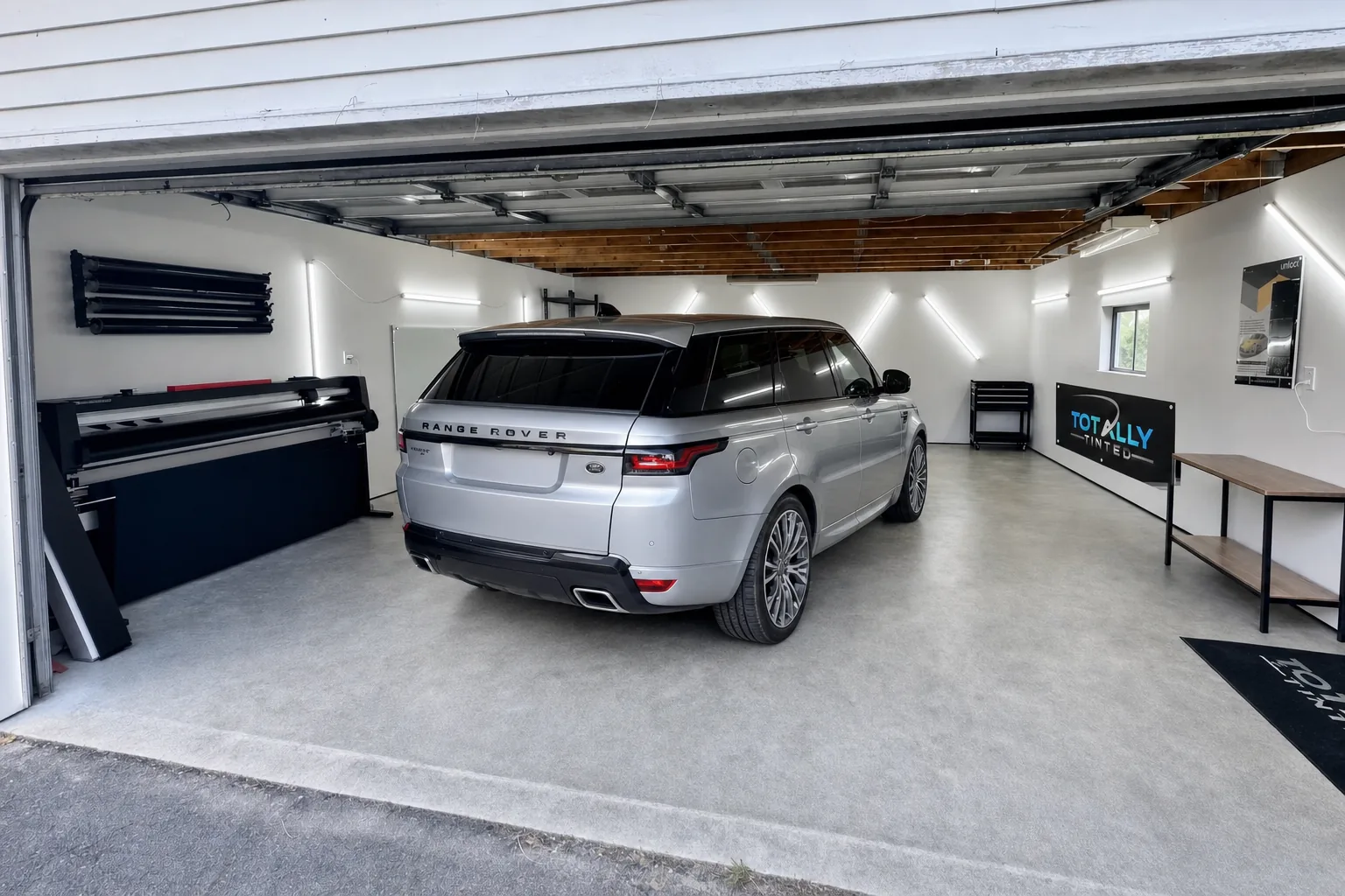 Liquid silver Range Rover Sport with freshly tinted windows in the Totally Tinted garage studio