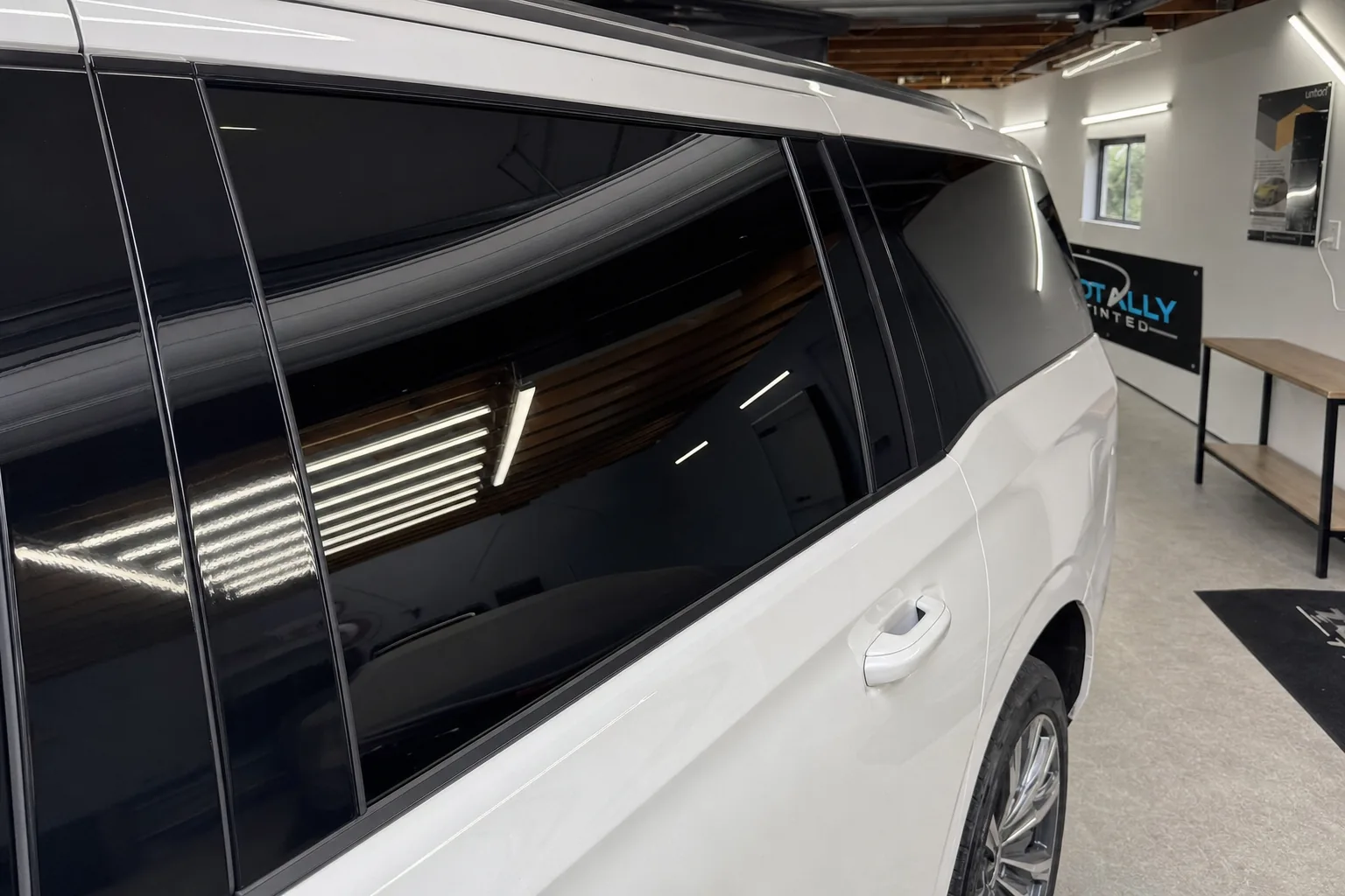 Pearl white Cadillac Escalade with freshly tinted windows in the Totally Tinted garage studio