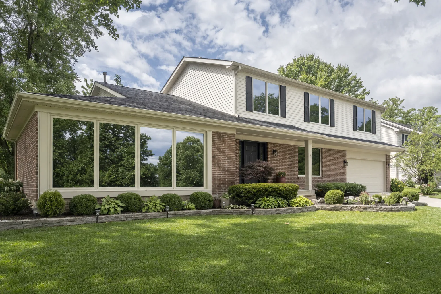 A two-storey home with reflective daytime privacy film on its big windows