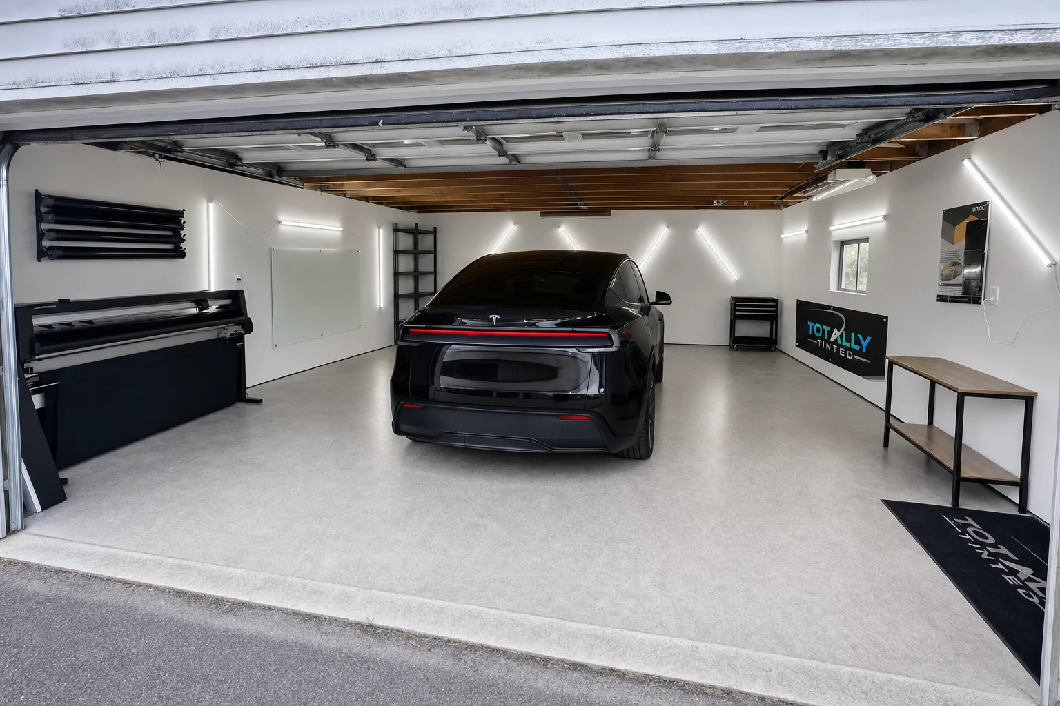 Gloss black Tesla Model Y Juniper with freshly tinted windows in the Totally Tinted garage studio